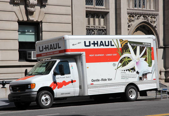 U-Haul moving truck parked outside the side of a building.
